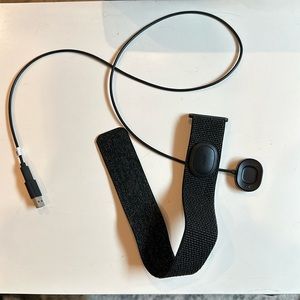 Peloton heart rate monitor and charger. For wearing around the forearm.